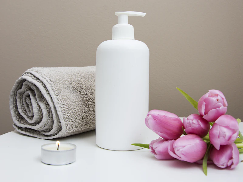 Rolled fresh towel, toiletries and flowers set out in a guest bathroom