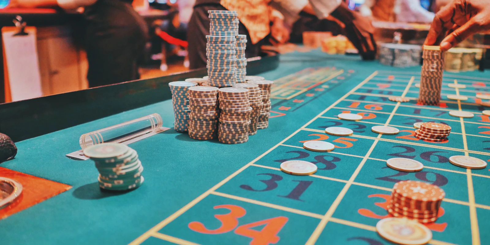 Roulette table on the casino floor, with stacks of chips on the felt and guests gathered around