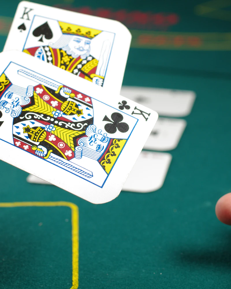 Playing cards being dealt across a green felt card table