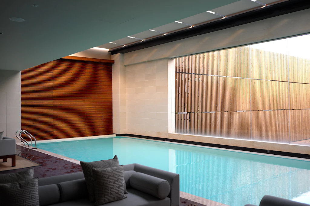 Indoor pool with timber-panelled walls and lounge seating