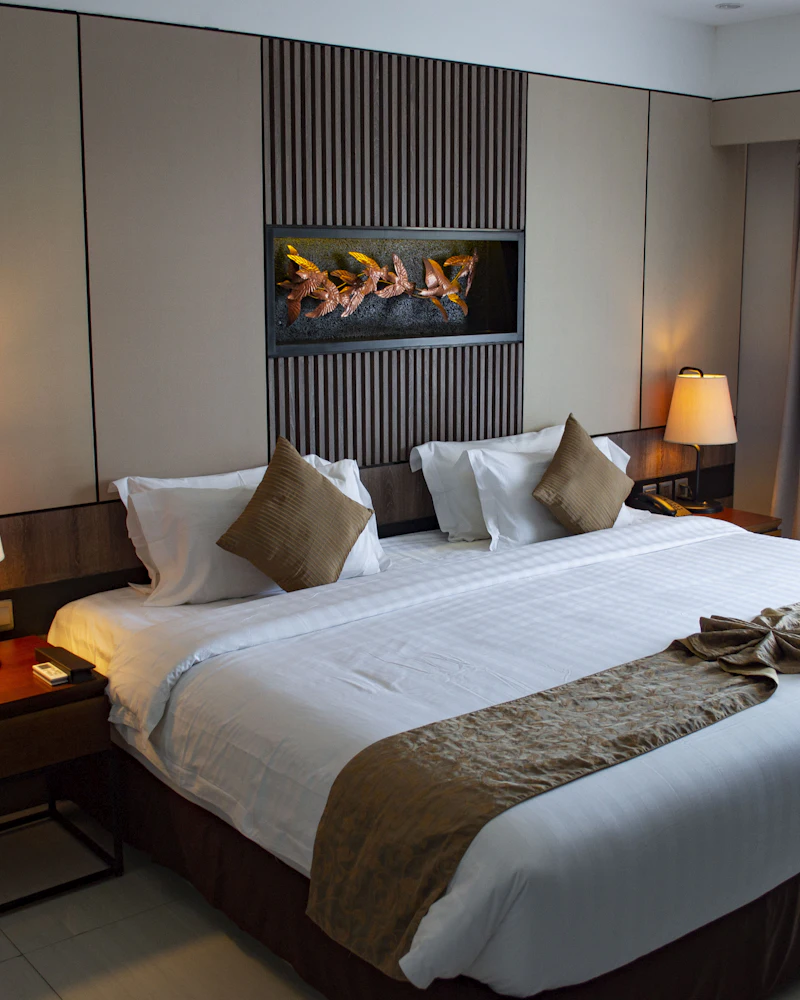 Deluxe hotel room with a king bed, warm bedside lamps and artwork above the headboard